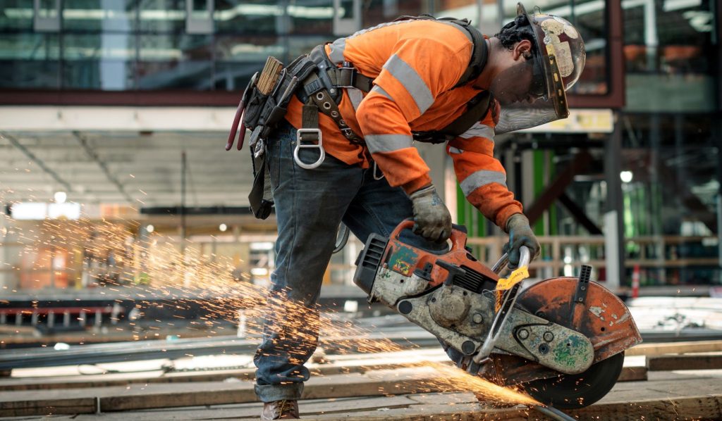 Sparks Fly as Construction Worker Saws Through Metal